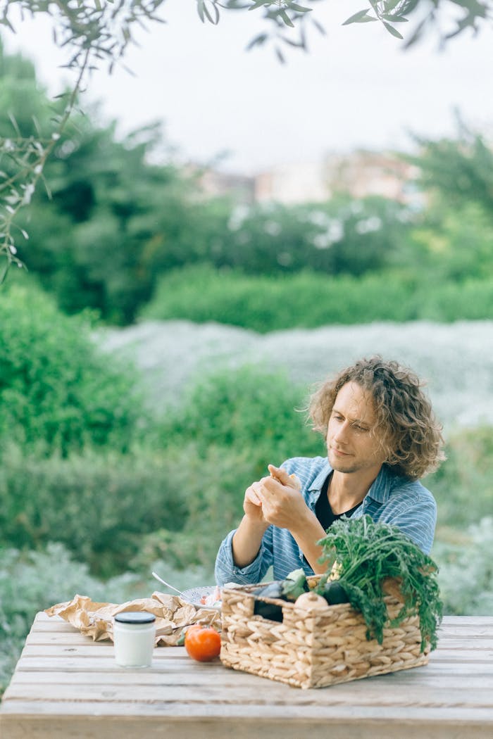 Crafting Captivating Headlines: Your awesome post title goes here An adult man sitting outdoors enjoying fresh organic produce, surrounded by nature.